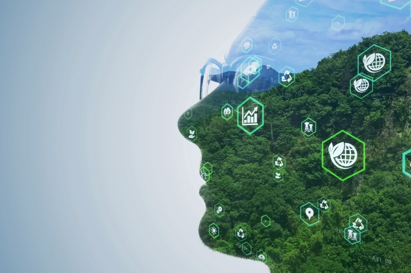 A digital composite of a person's profile overlaid with a lush green forest, symbolizing sustainability and environmental awareness